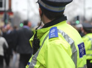 A police community support officer looks down the street. 