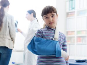 An injured child has their arm in a sling. 