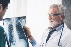 A doctor shows a patient a chest x-ray.