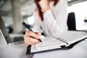 A solicitor sits at a desk writing. 