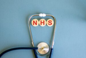 A doctors stethoscope has NHS next to it to signify NHS employment.