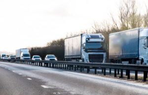 Several HGV and cars are travelling on a motorway. 