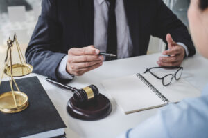 A solicitor works at a desk with a gavel on it. 