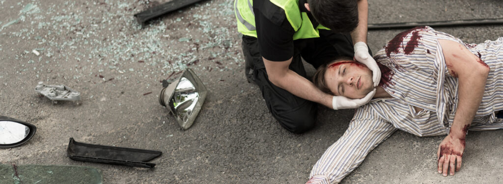 a person lying on the ground after suffering a catastrophic head injury after car collision