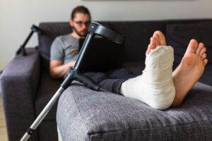 MAN WITH BROKEN LEG LOOKING AT LAPTOP