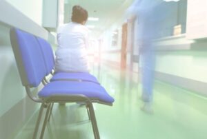 Doctor sitting on a chair in a hallway within a hospital