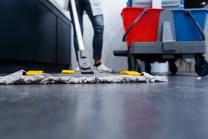 PERSON MOPPING FLOOR IN A WORKPLACE