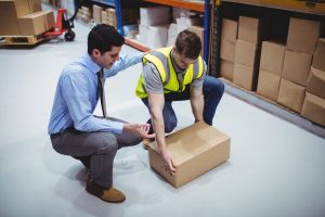 EMPLOYER INSTRUCTING A WORKER ON HOW TO LIFT A BOX SAFELY