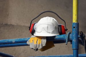 A hard hat and gloves resting on scaffolding.