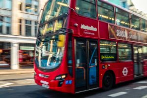 A red bus driving down the road.