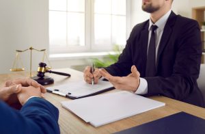 A serious injury solicitor sat at a desk talking to a client.